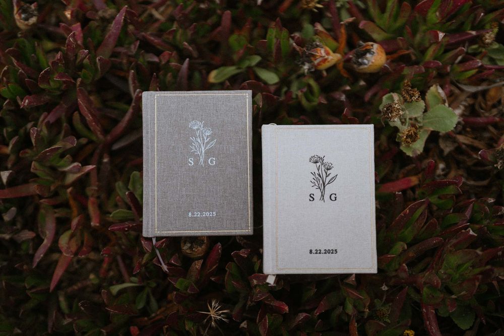 Elegant gray wedding invitation cards arranged on dark foliage.