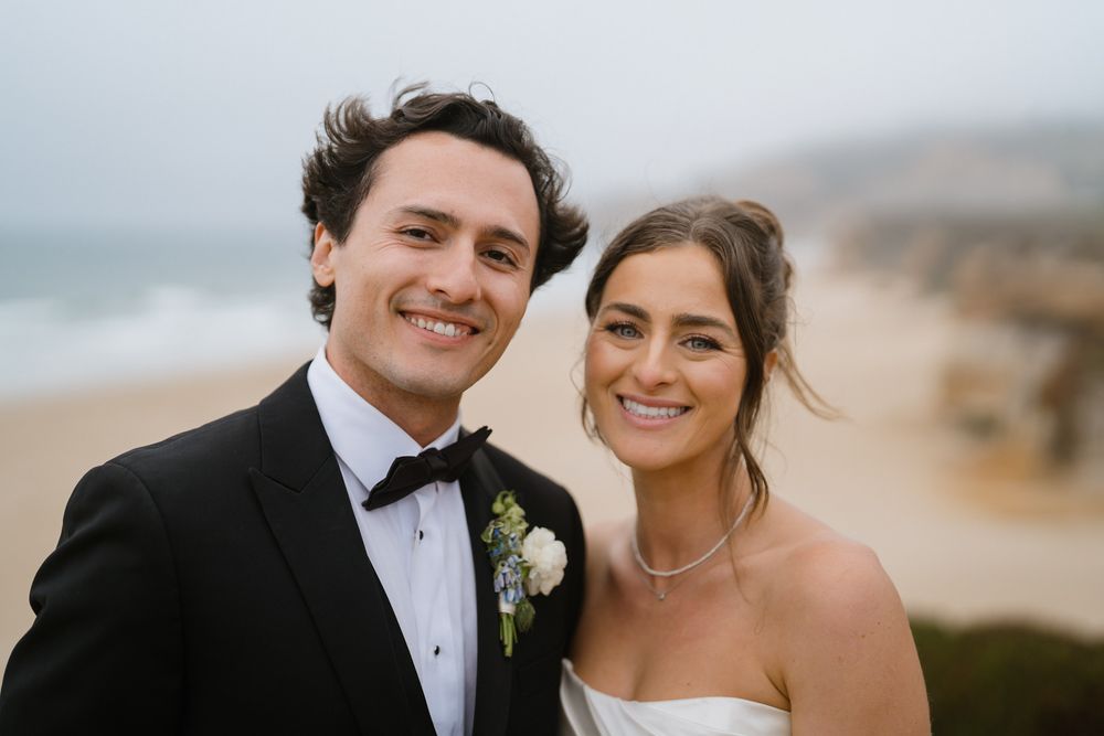 Formal wedding portraits captured against a misty coastal backdrop.