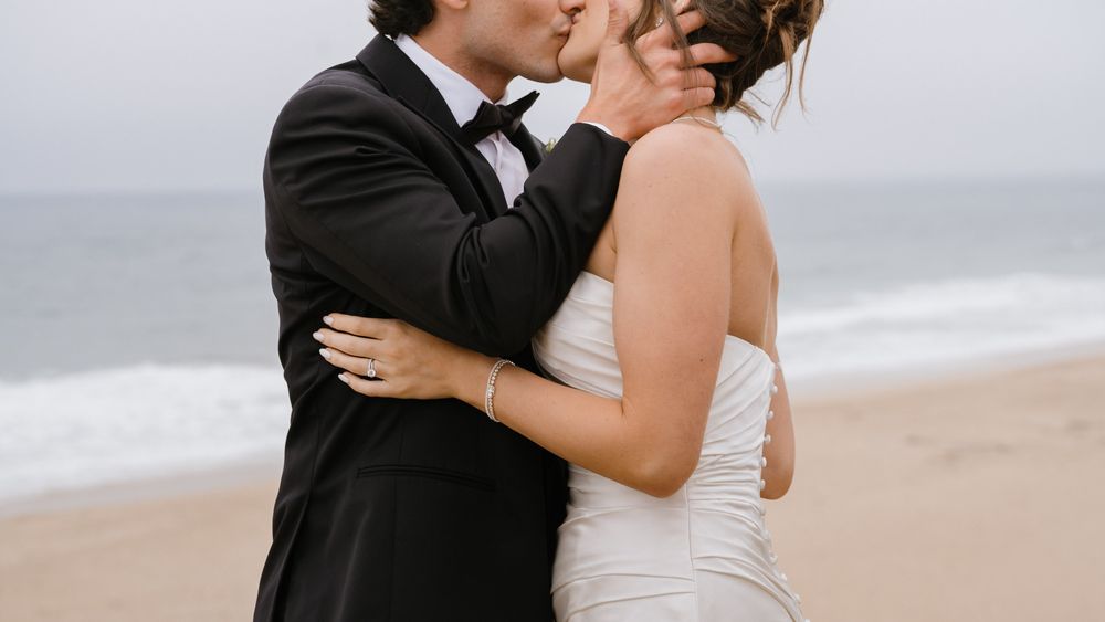 A couple shares an intimate moment during their beach wedding ceremony.