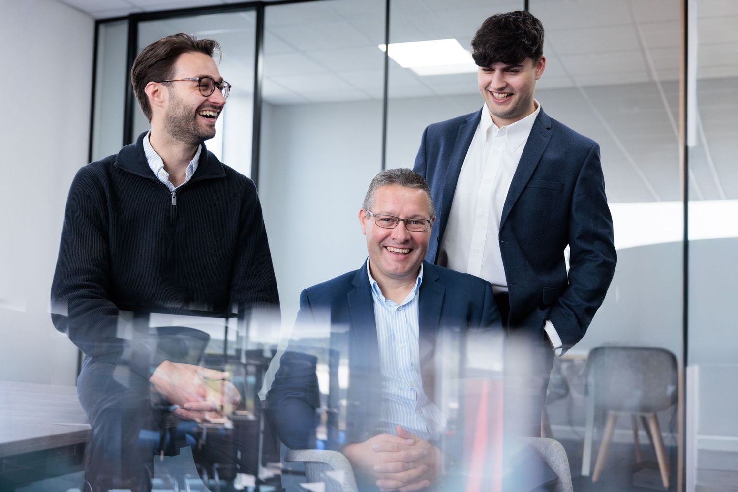 Business professionals having an animated discussion in a modern office meeting room. Family Corporate Photography