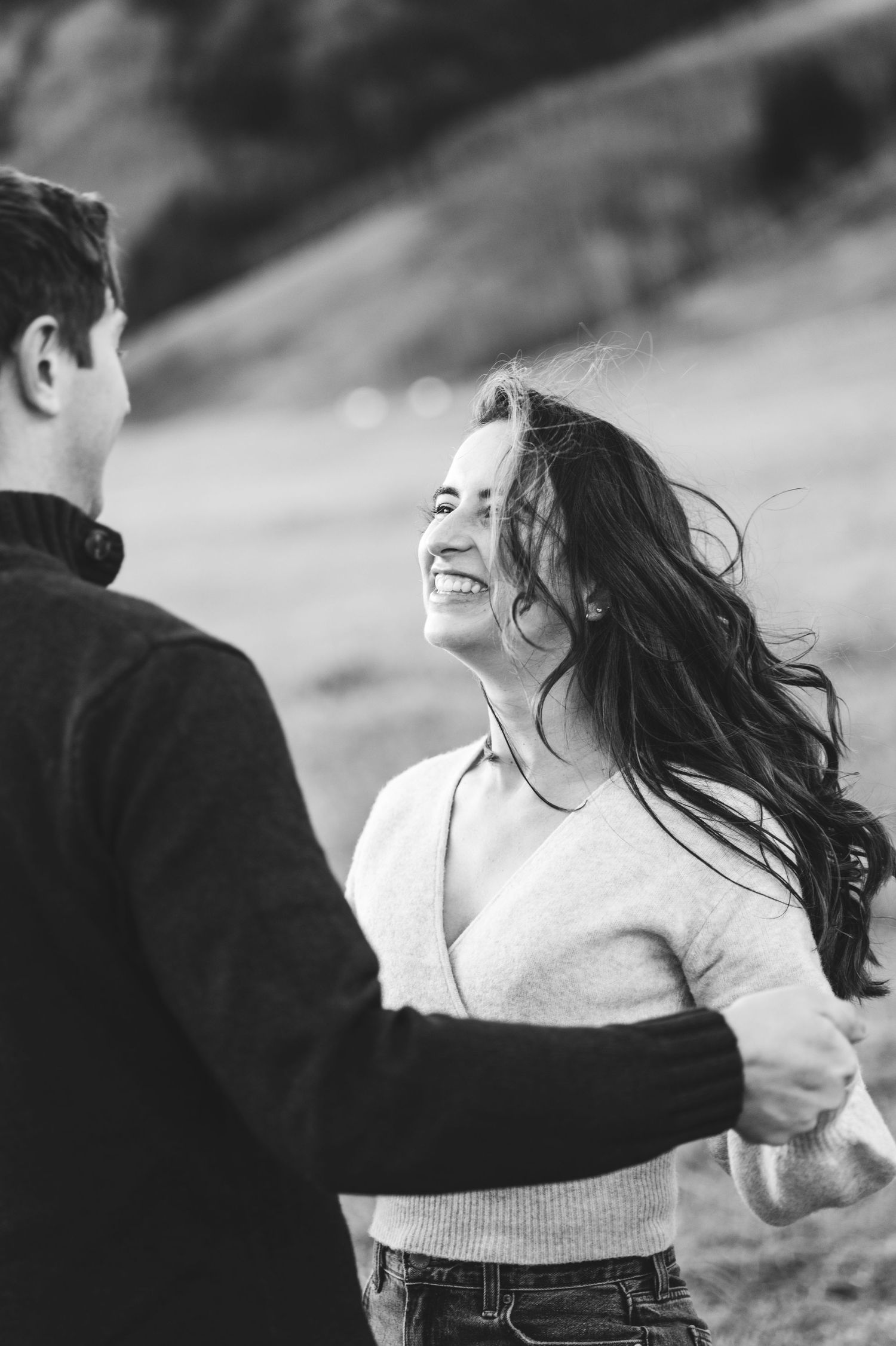 Black and white candid shots of a couple laughing and dancing outdoors.