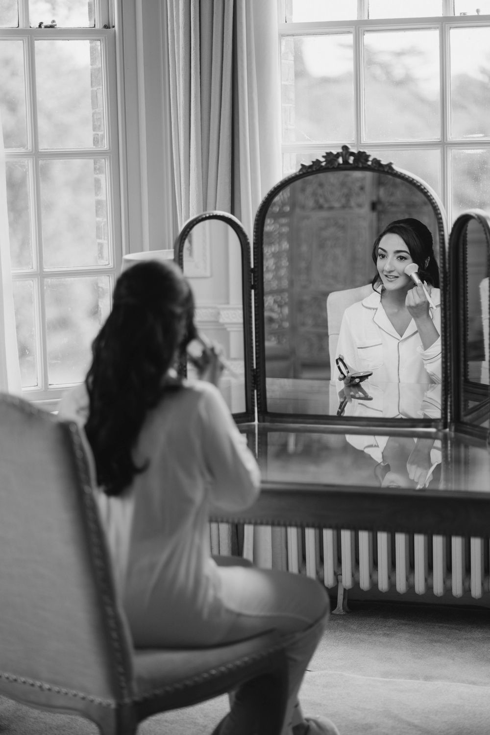 Black and white series showing bride looking in mirror during wedding preparation.