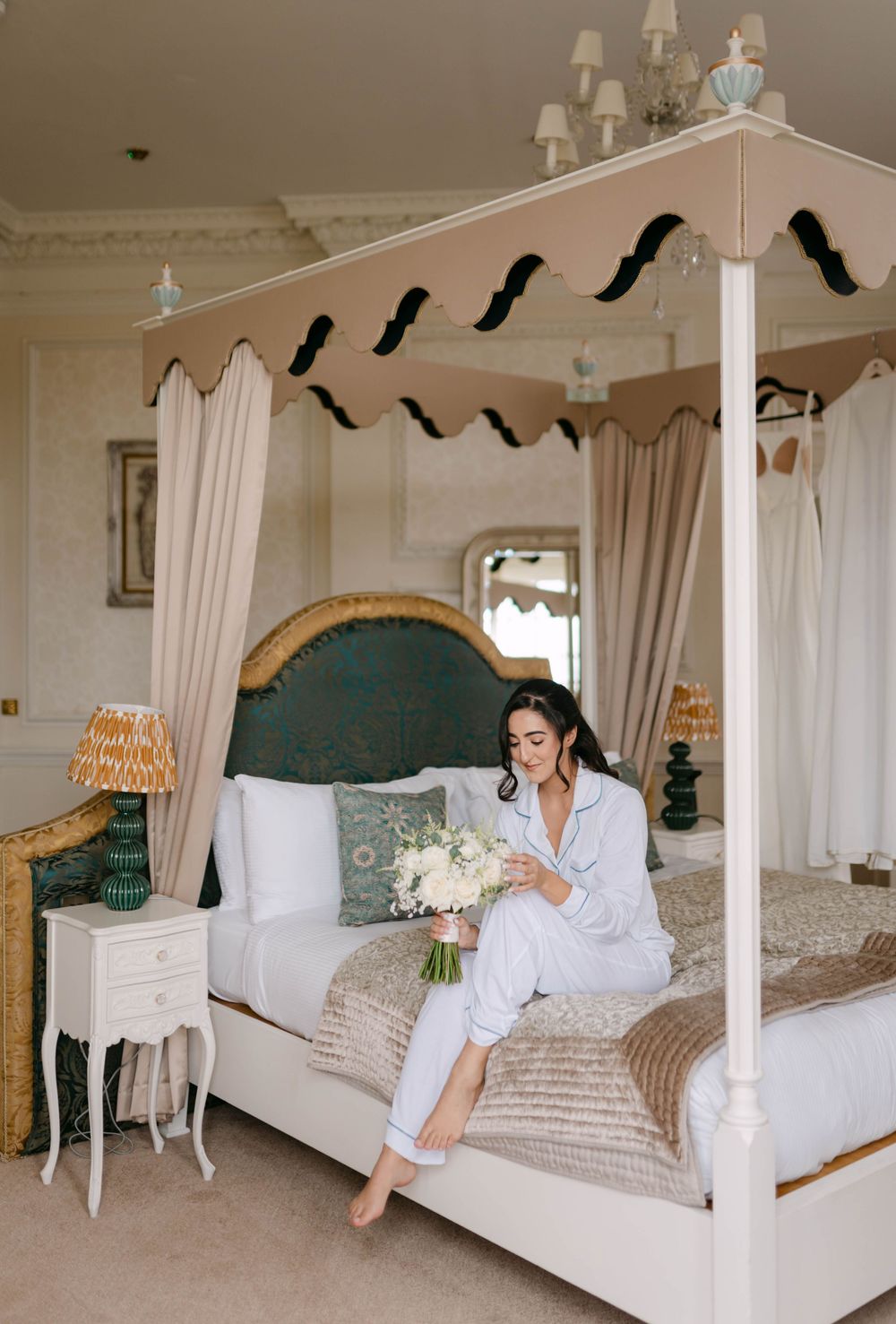 Elegant bedroom with four-poster bed, white curtains, and teal accents.
