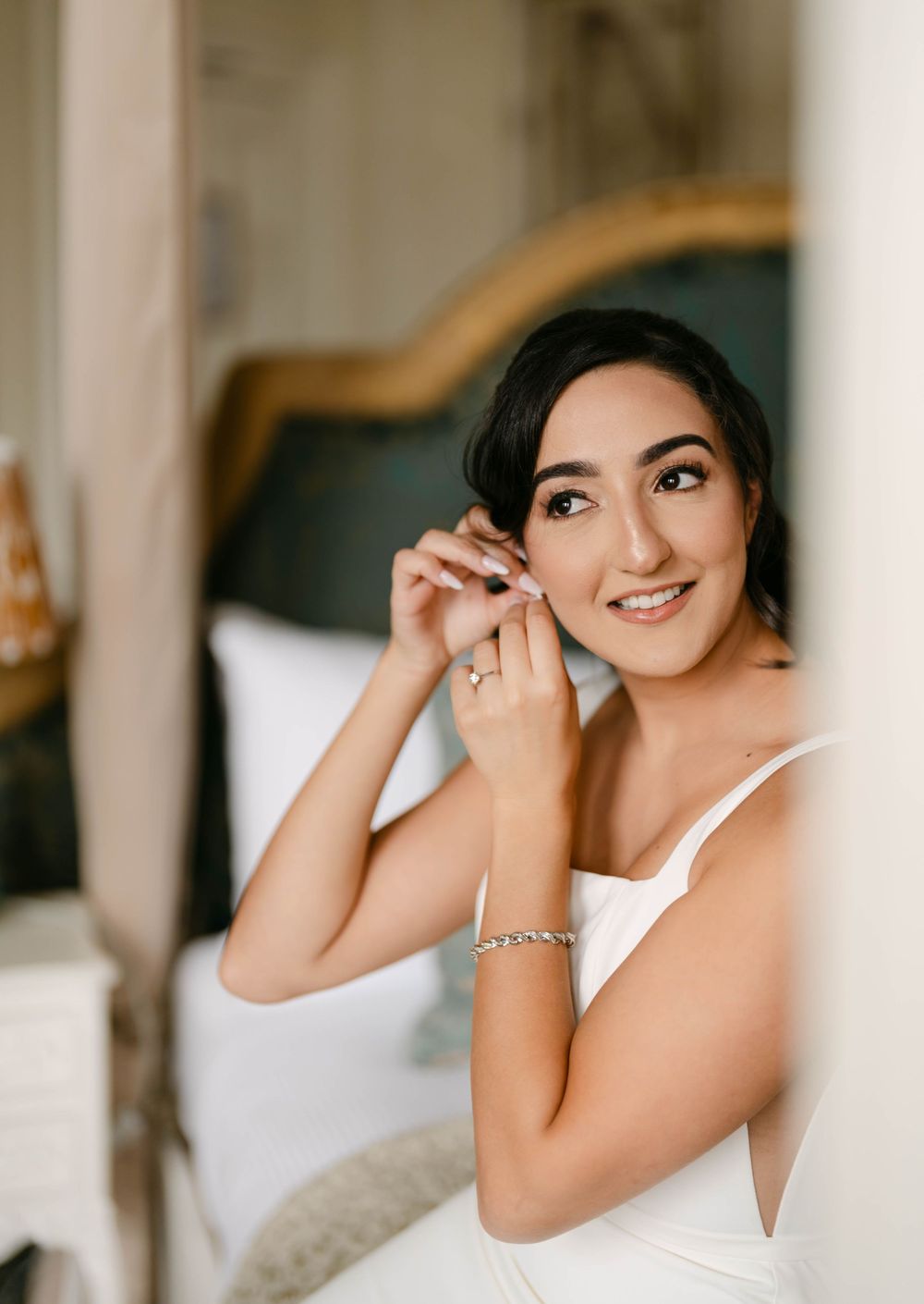 Soft focus portrait shot through sheer curtains in natural window light.