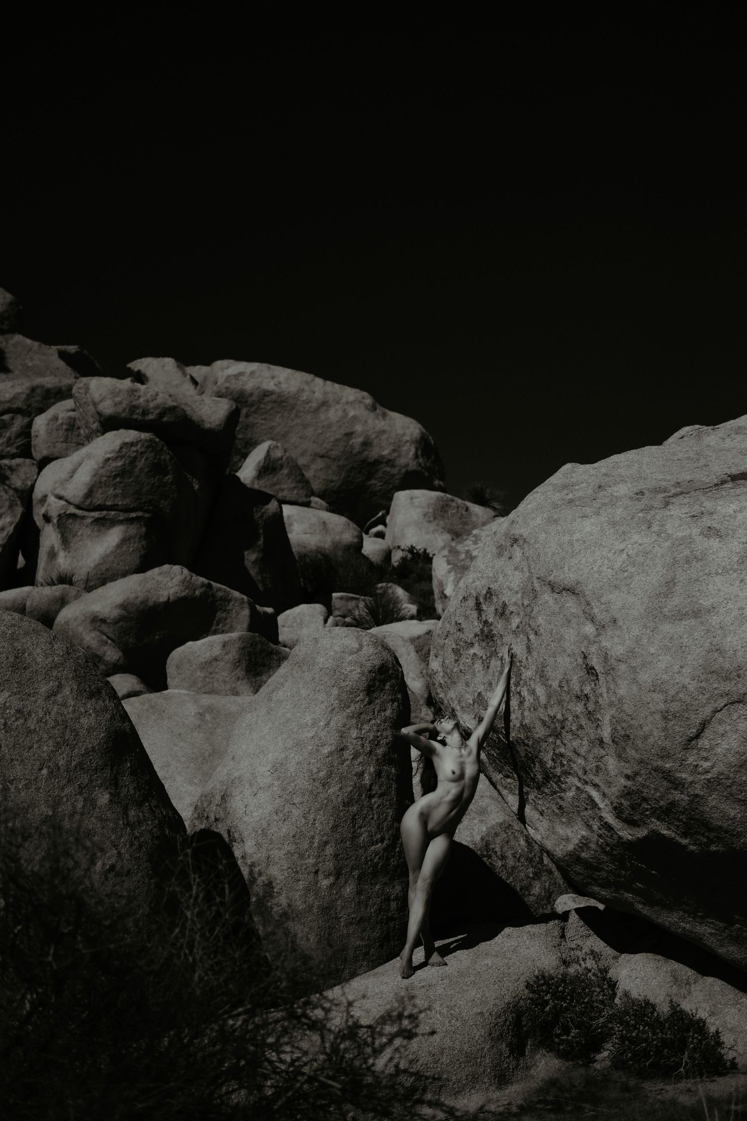Joshua Tree National Park Outdoor Boudoir session of artistic nude woman near large boulders.