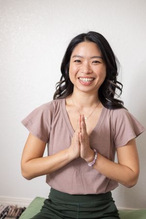 Yoga and meditative instructor sitting with hands in front of heart space for headshot photo in Kirkland, WA