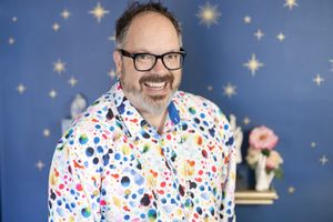 James Divine palm reader headshots man with colorful polka dot shirt and blue star wall smiling in Seattle, WA