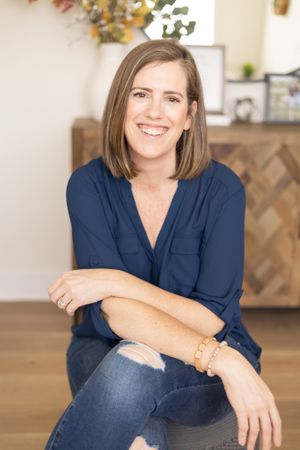 woman owned reiki master business sitting in livingroom for lifestyle headshots looking at camera smiling