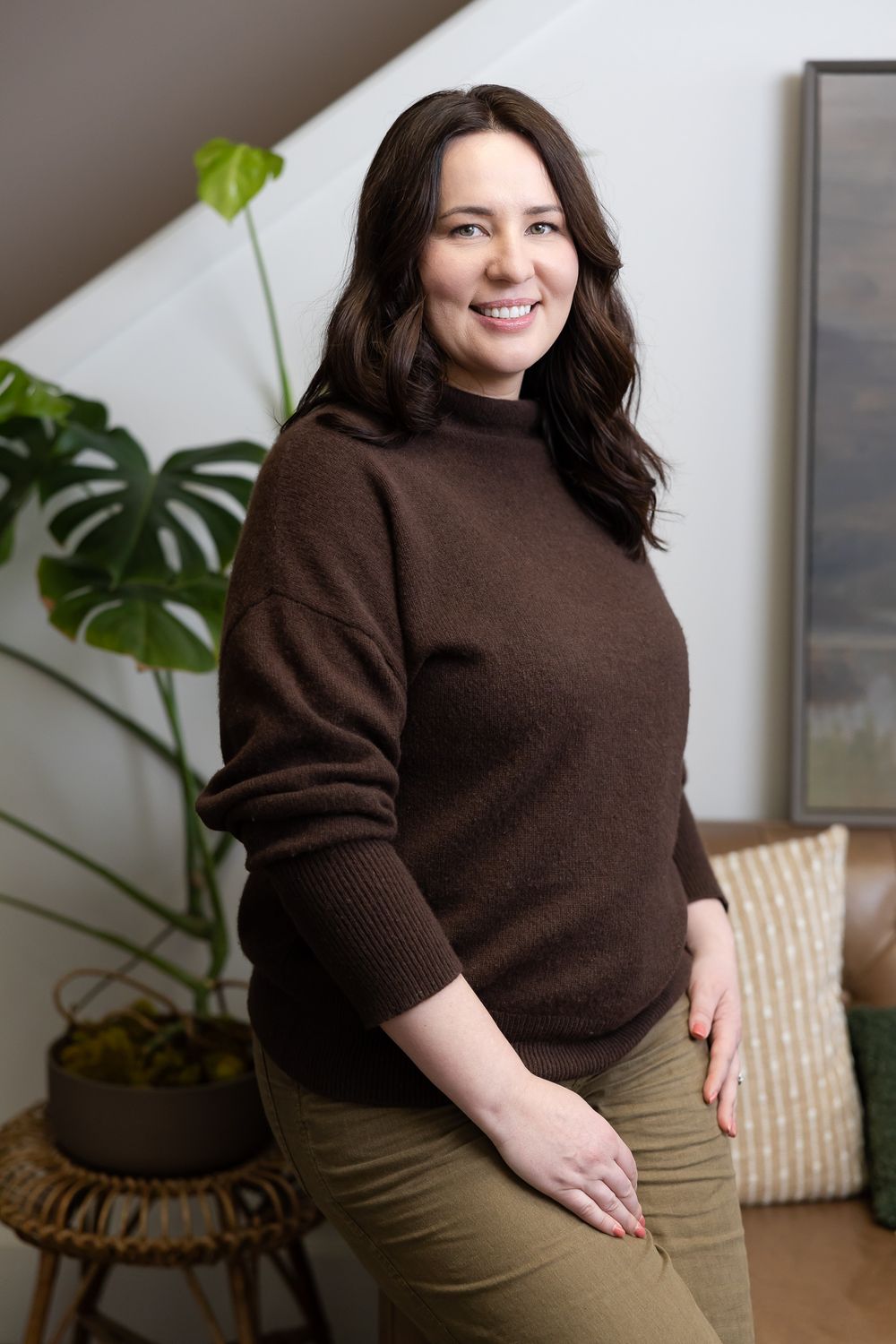 female mental heal therapist in Tacoma, WA sitting in client waiting area on couch smiling for lifestyle headshot