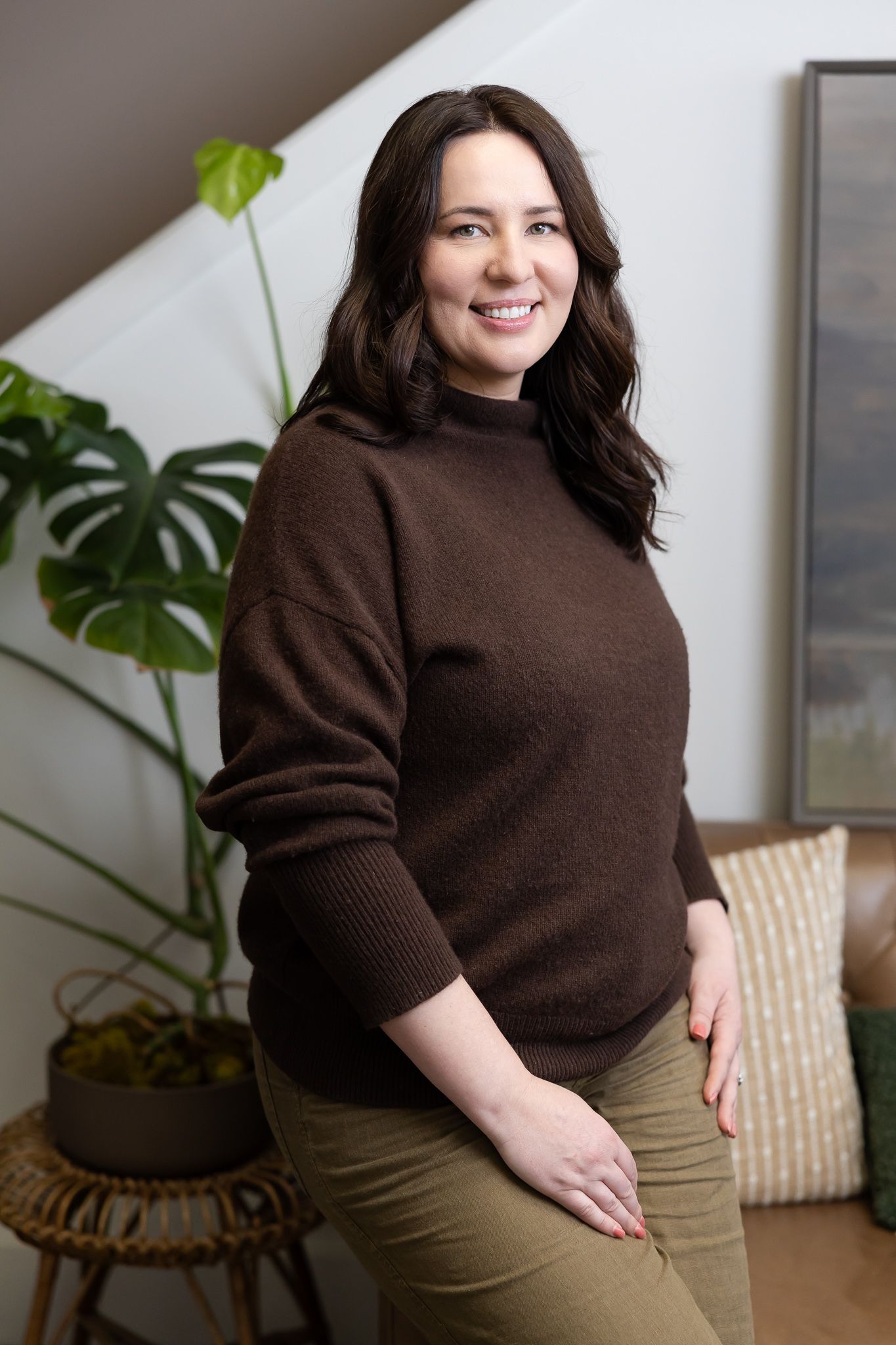 female mental heal therapist in Tacoma, WA sitting in client waiting area on couch smiling for lifestyle headshot