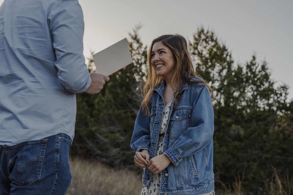 Couple sharing emotional moment while exchanging notes outdoors.