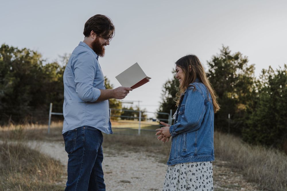 Couple in casual attire sharing special moment on hillside path.