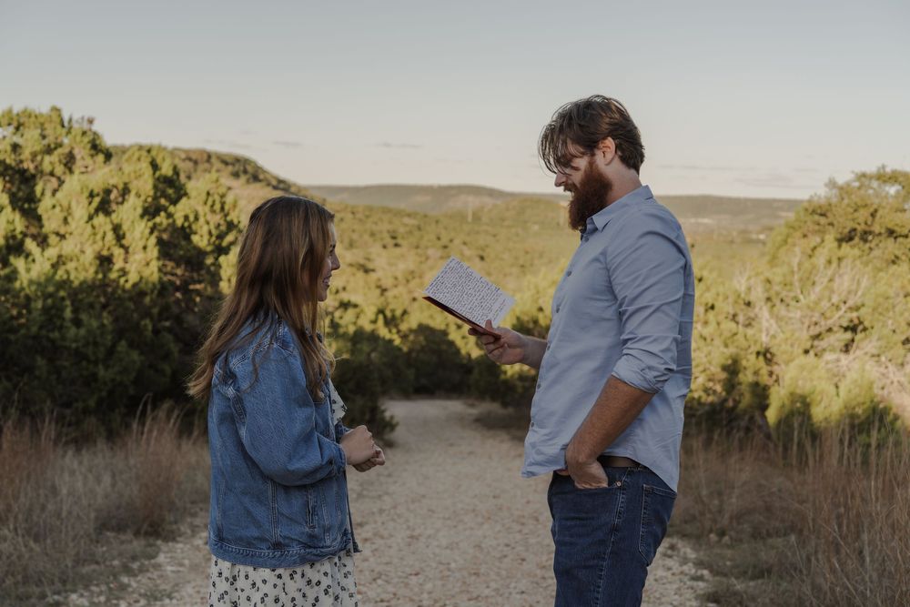 Couple exchanging notes on scenic desert trail during golden hour.
