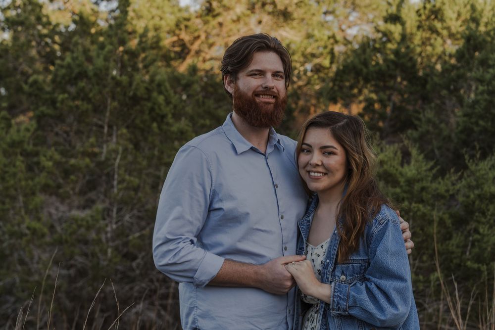 A romantic outdoor photoshoot in a natural setting with golden sunlight.