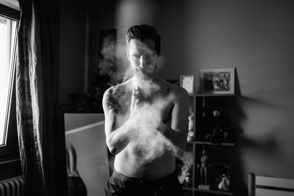 Artistic black and white photo series showing wedding preparations in a room with dramatic lighting.