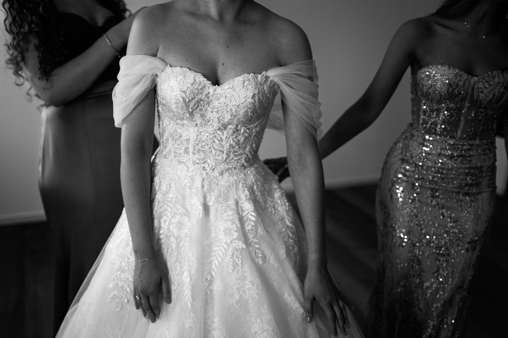 Elegant white wedding dresses on display showcasing intricate lace and beaded details.