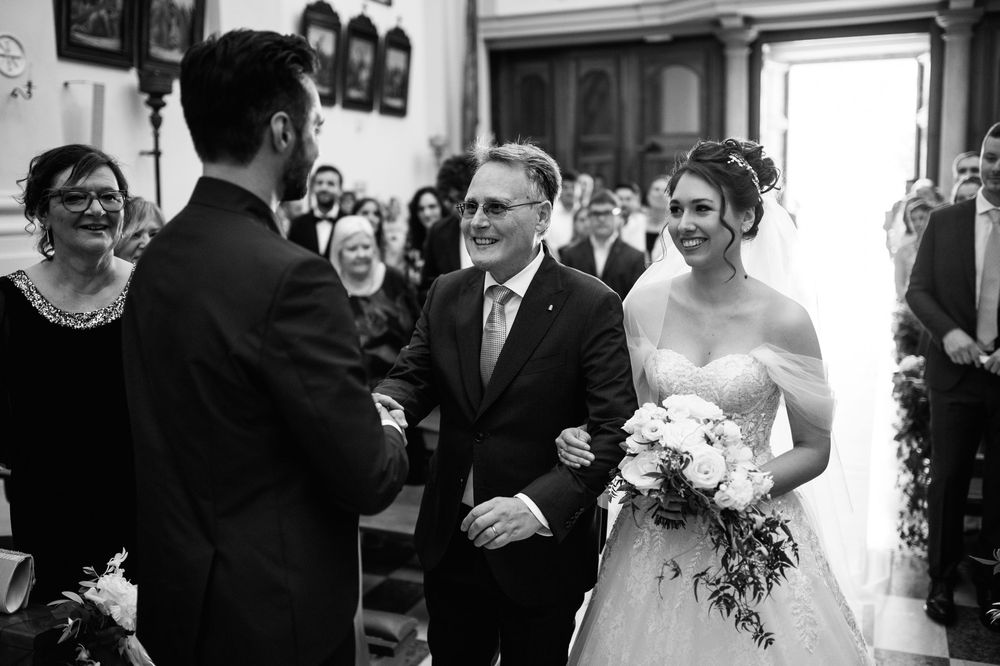 Black and white photo of an emotional wedding ceremony moment in a traditional church setting.