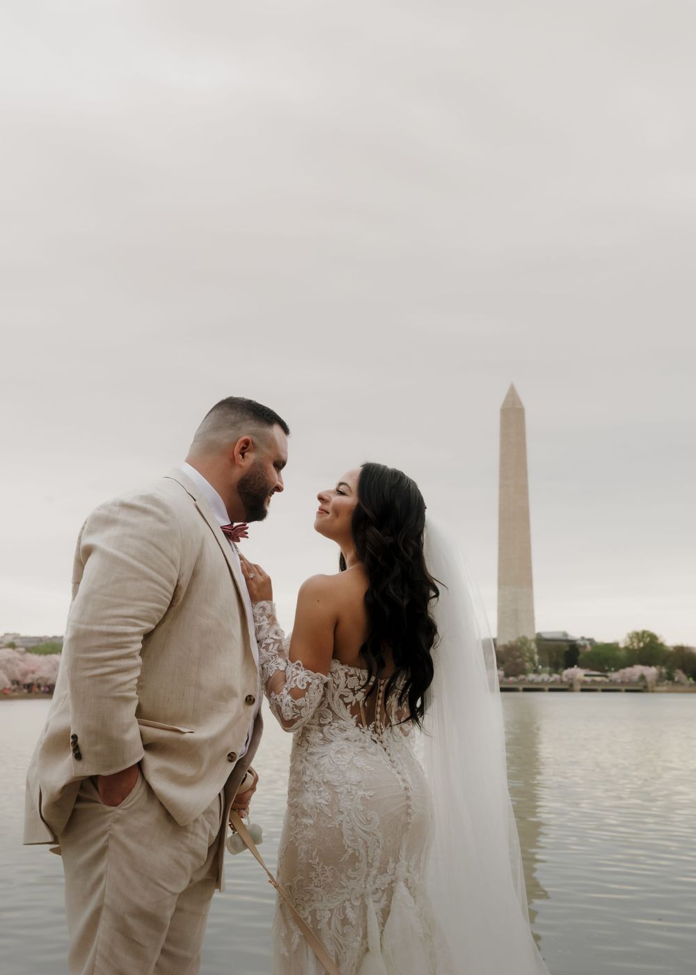 A romantic wedding photo series by the Washington Monument reflecting pool showing tender moments between newlyweds.