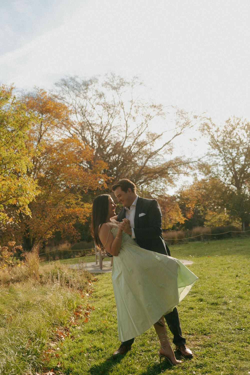 A romantic autumn photoshoot with golden sunlight in a grassy field.