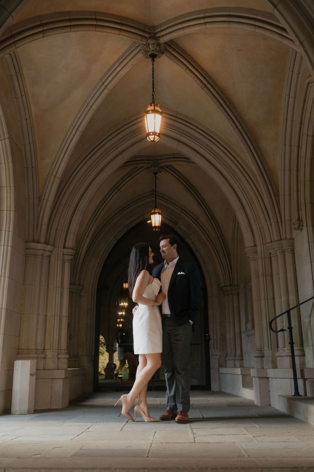 A romantic moment captured in a vaulted stone corridor with hanging lanterns.