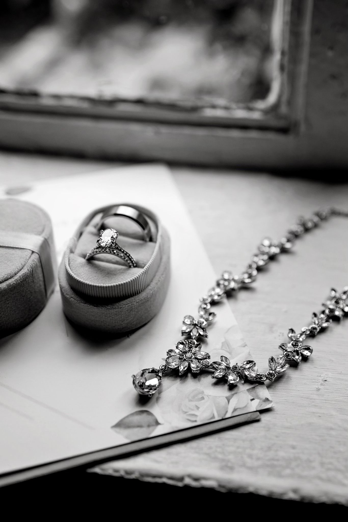 A series of black and white close-up photos showing wedding rings and diamond jewelry arranged artistically.
