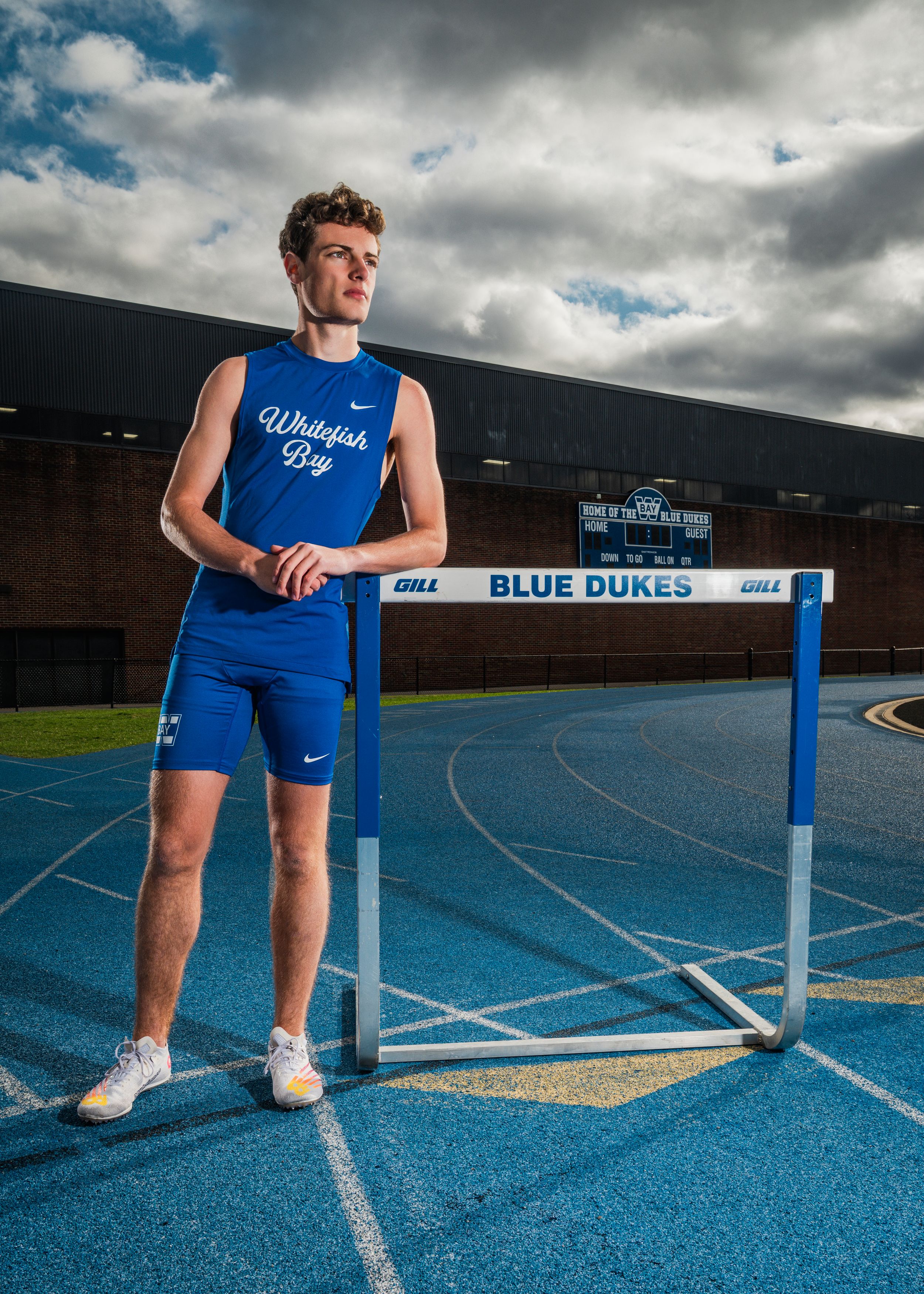 Track and field hurdle setup on blue running track with Blue Dukes branding visible.