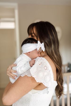 A tender series of photos showing a mother in white embracing a small child wearing a white outfit.
