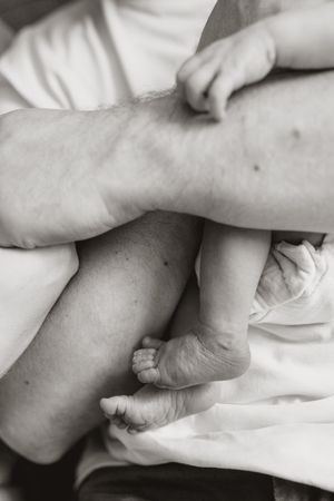 A series of black and white close-up photographs showing gentle hand-holding gestures against a light background.