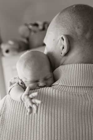 A sequence of black and white photos showing a sleeping baby resting peacefully on someone's shoulder.