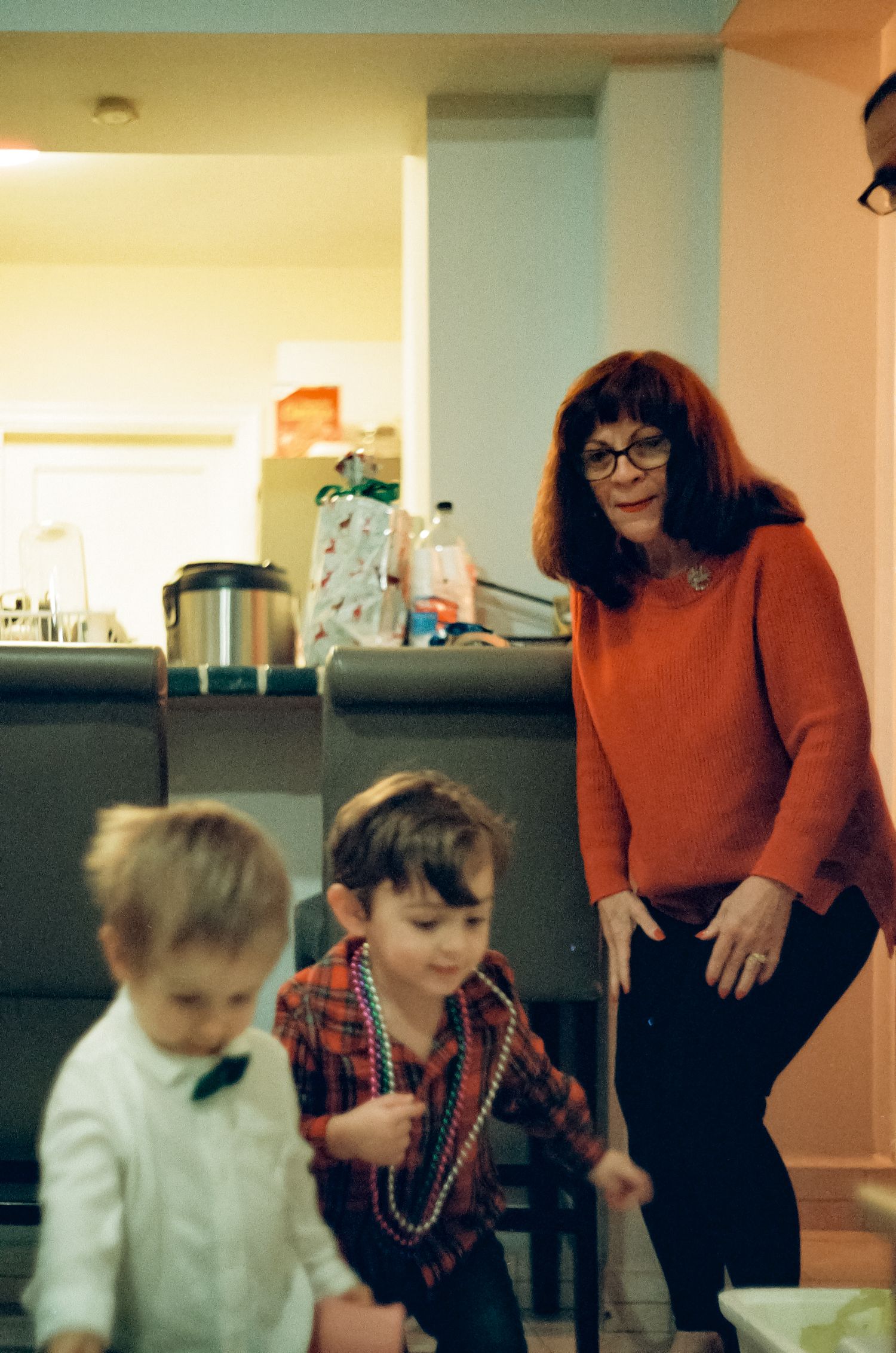Family gathering in a kitchen with decorative beads and holiday decor.