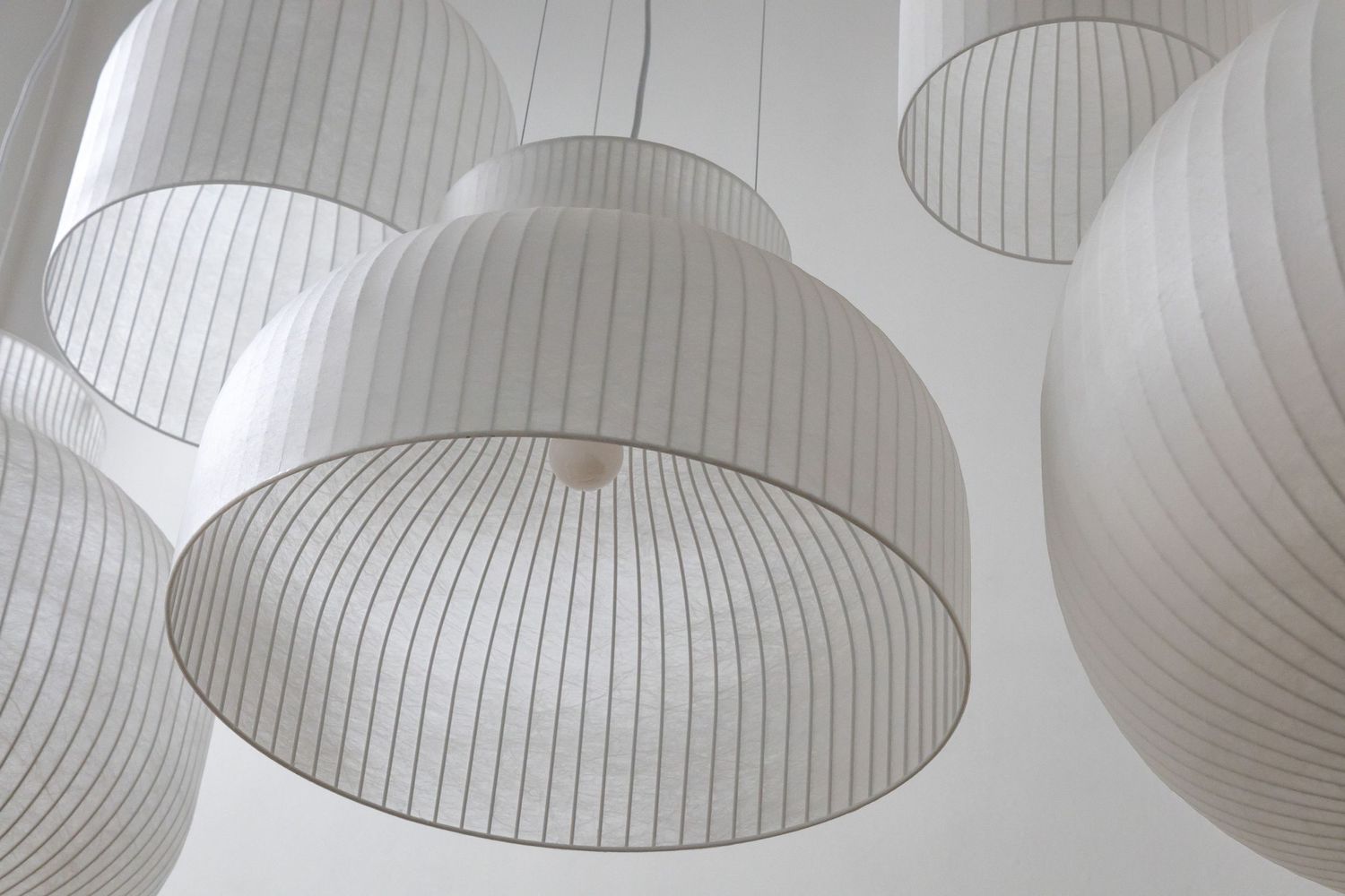 Modern white dome pendant lantern lights with ribbed texture hanging from ceiling.