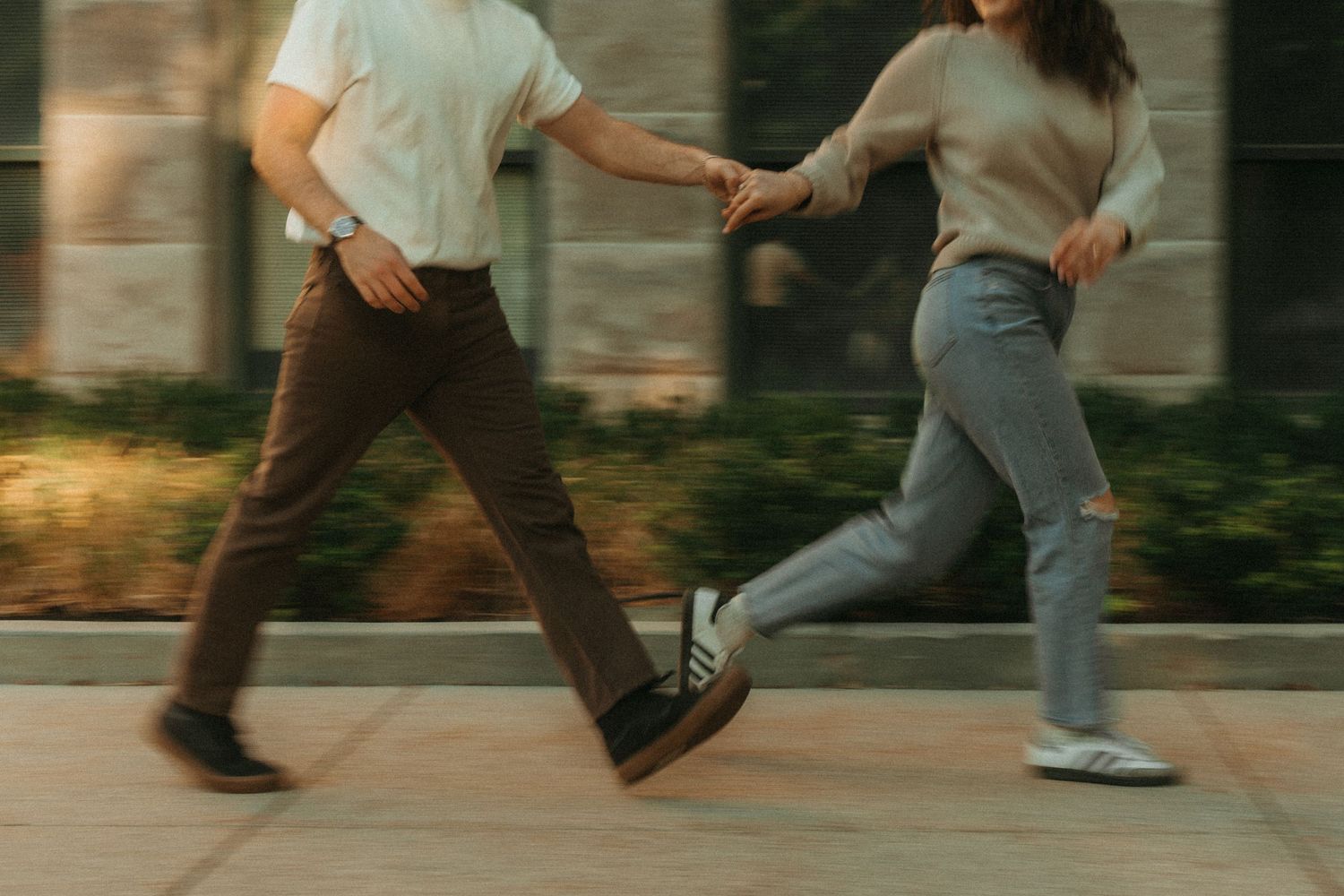 A series of legs and feet shown in motion walking across a frame in warm afternoon lighting.