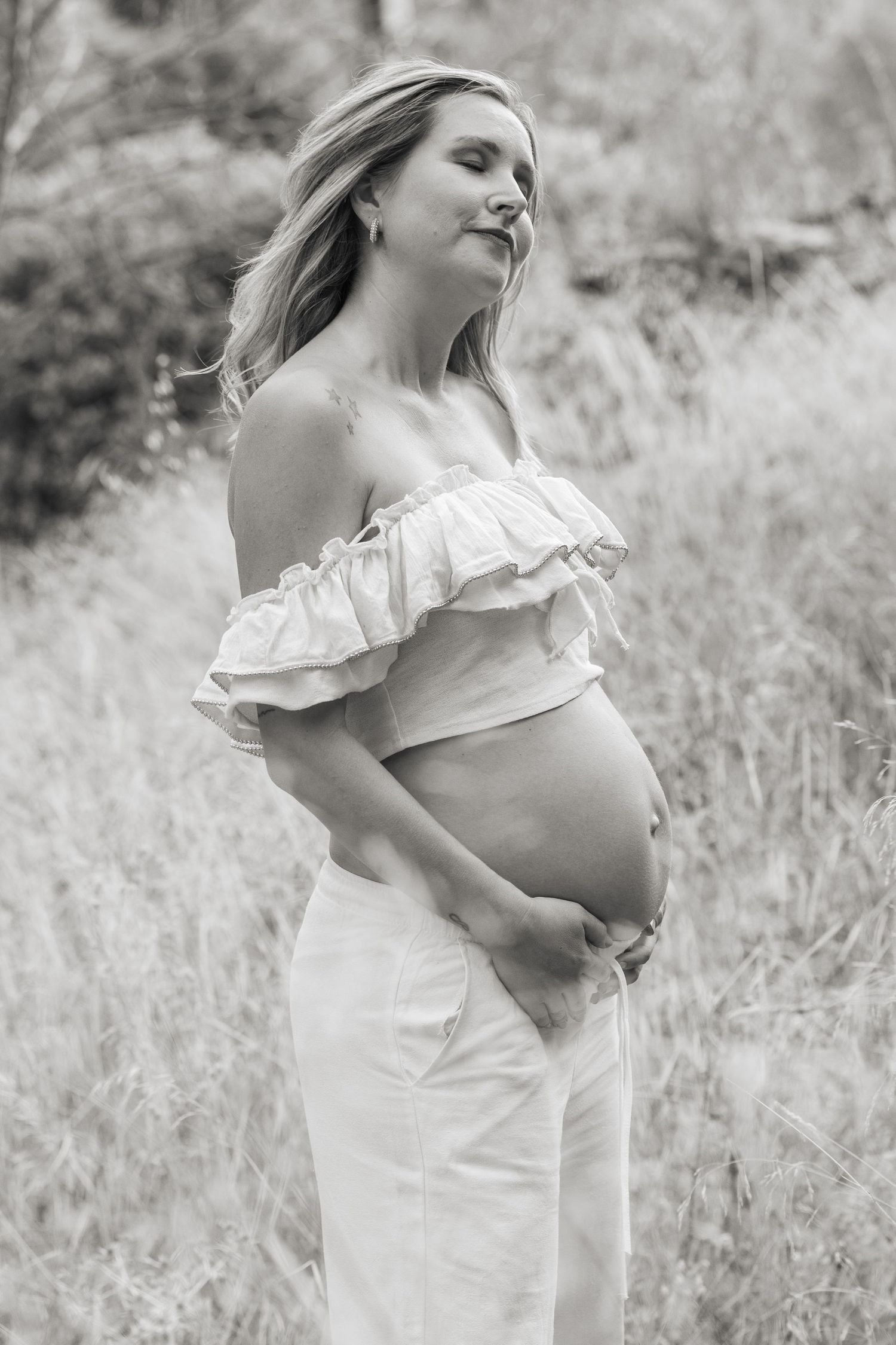 A maternity photo series showing a couple's hands cradling a pregnant belly against an outdoor natural background.