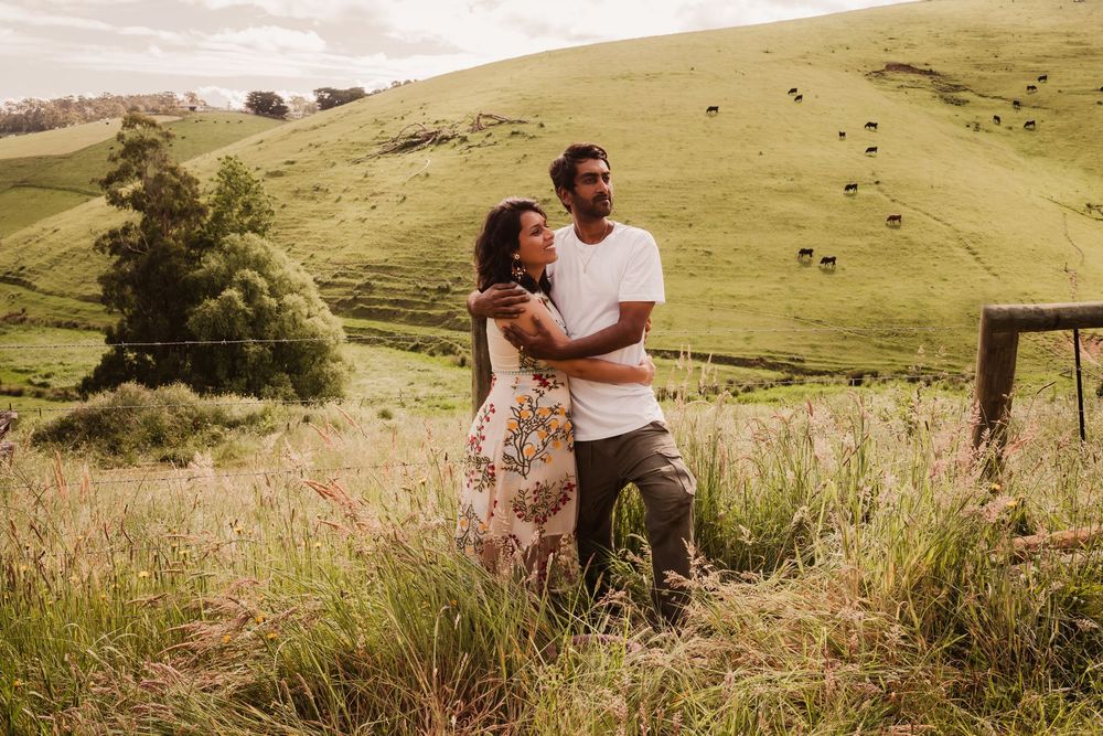 A scenic mountaintop engagement photo session captured in golden light across rolling green hills.