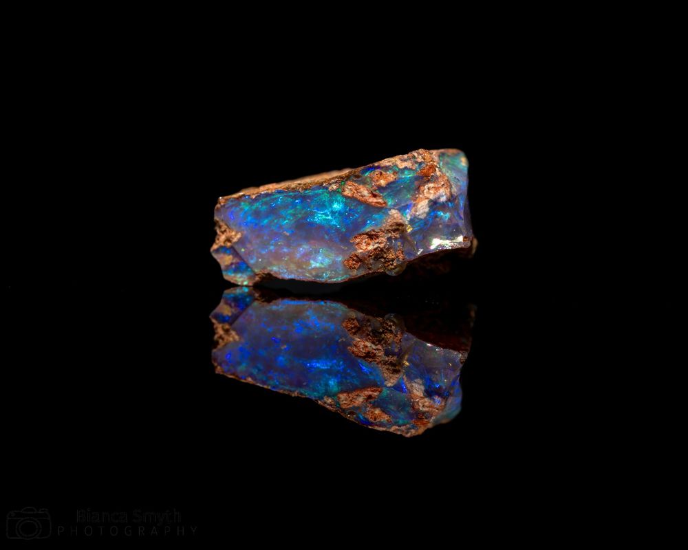 Close up (macro) of small piece of opal with black background.