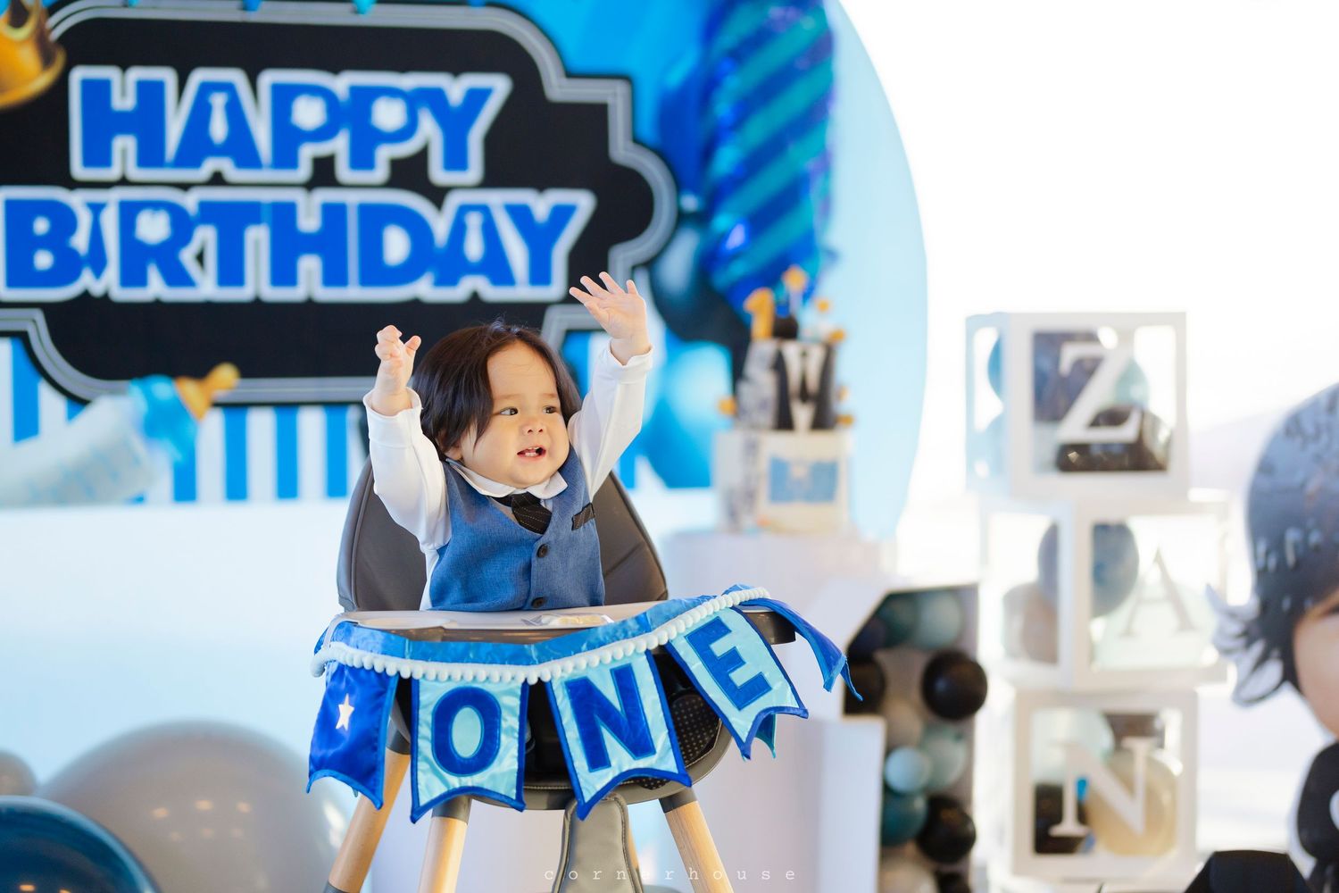 Blue and black birthday party decorations with a 'Happy Birthday' banner and one-year milestone theme against white background.
