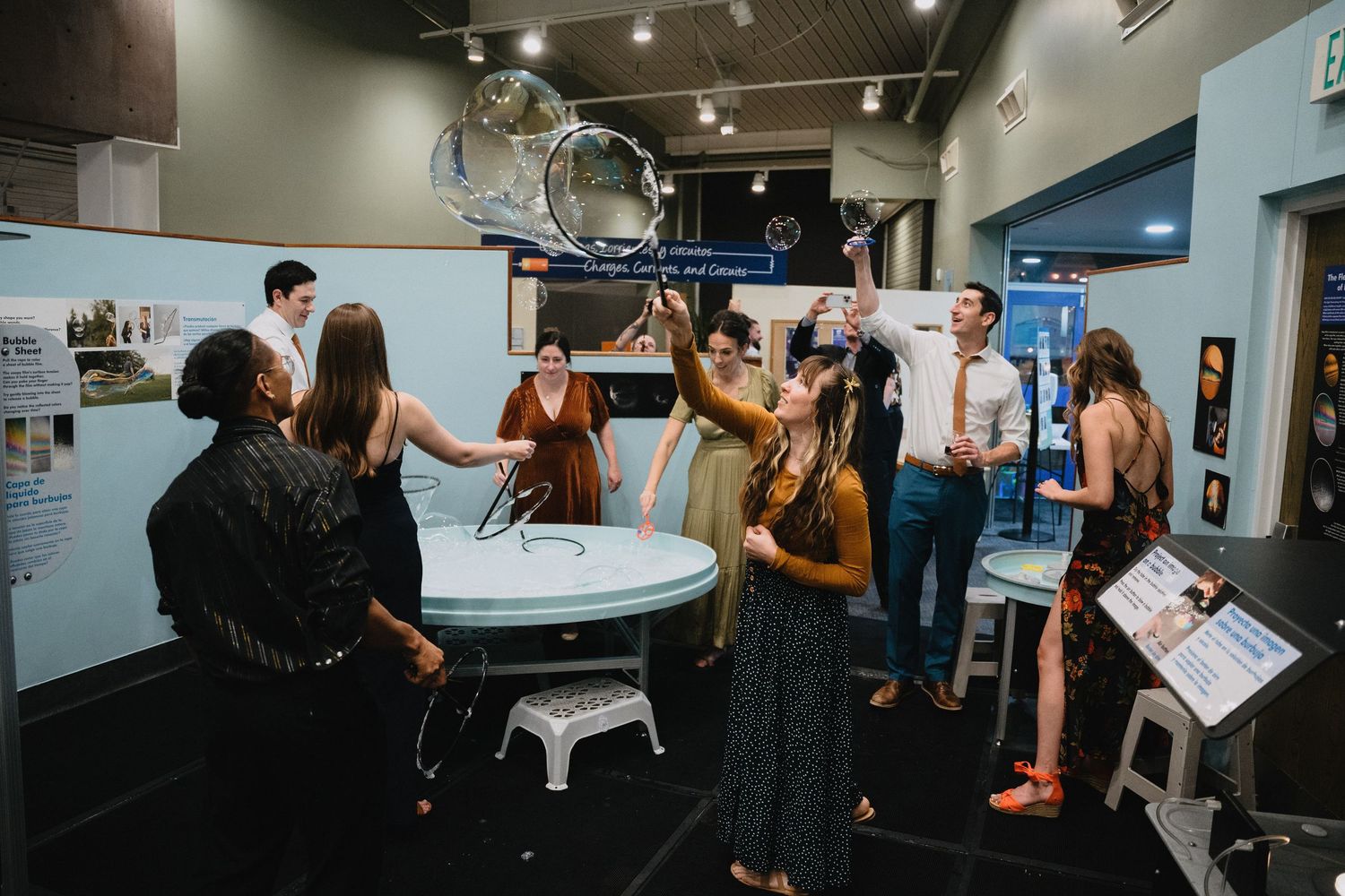 Wedding guests interact with a large musical instrument display inside a museum venue.cinematic wedding photographer new mexico