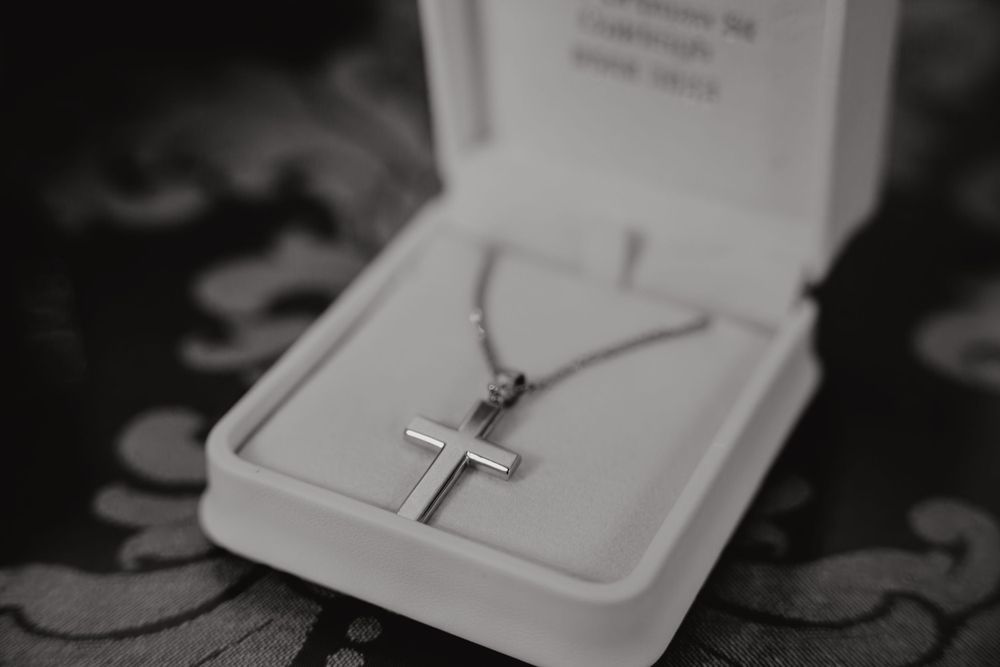 Detailed shot of the child’s cross necklace after baptism, perfectly framed in Melbourne’s church light, highlighting its spiritual signific