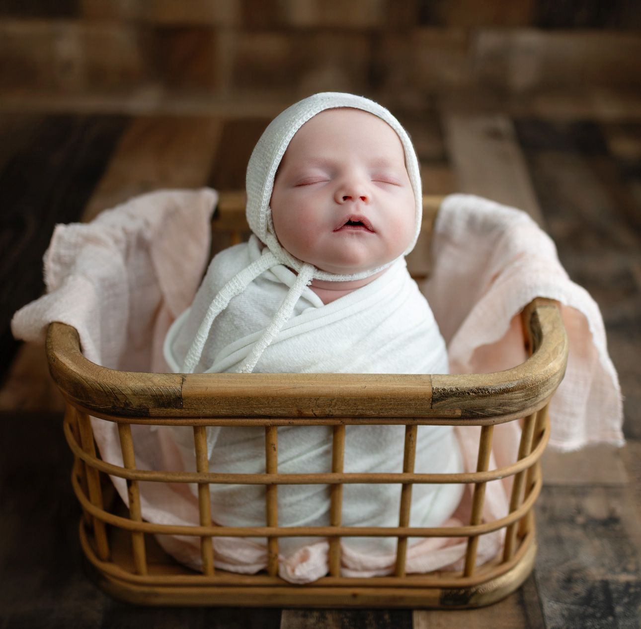 Vintage metal bucket with wooden handle sits empty on rustic wooden floorboards.