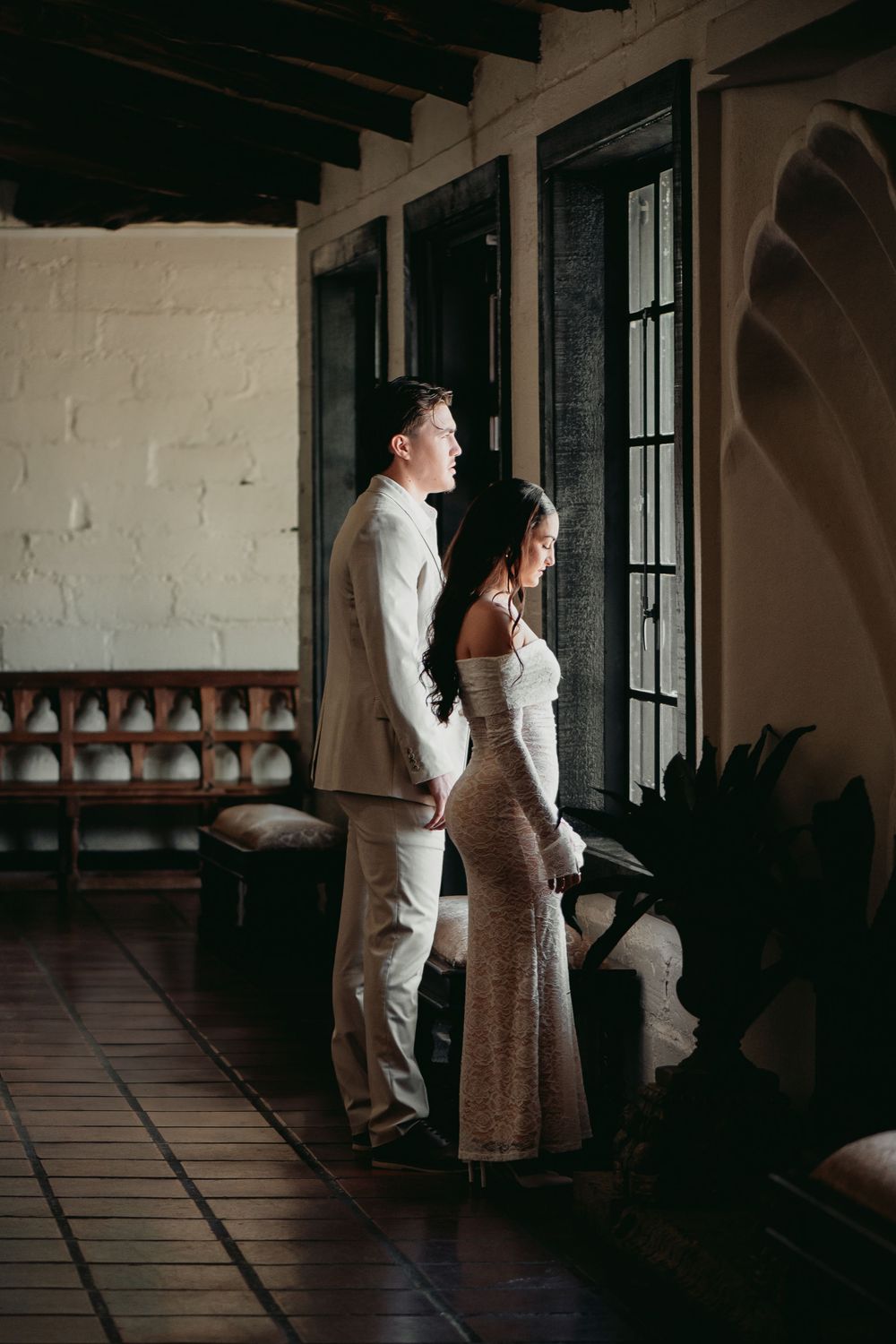 A wedding couple shares intimate moments in a sequence of sepia-toned photos along a covered porch hallway.