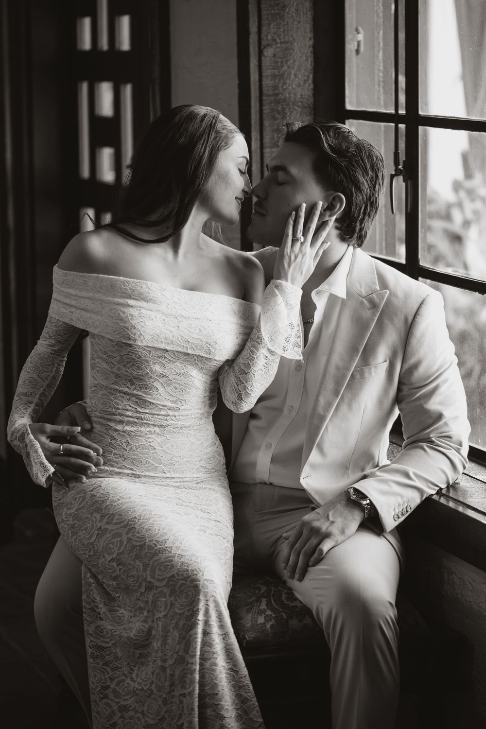 Series of romantic black and white photos showing a couple seated by window in vintage style wedding attire.