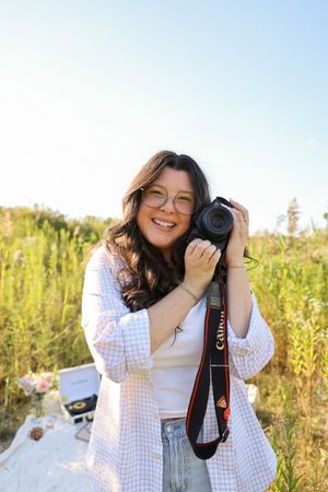 Camera equipment and photography setup in a sunny meadow with natural lighting.