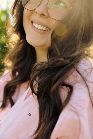 Candid expressions and smiles captured in soft lighting wearing pink and round glasses.