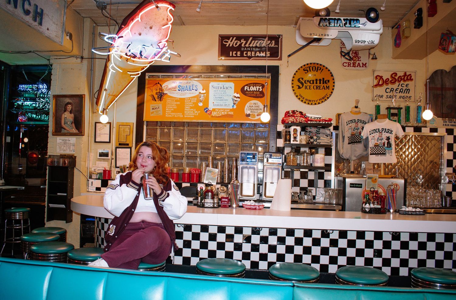 Seattle senior posing in retro diner booth during personality-filled portrait session