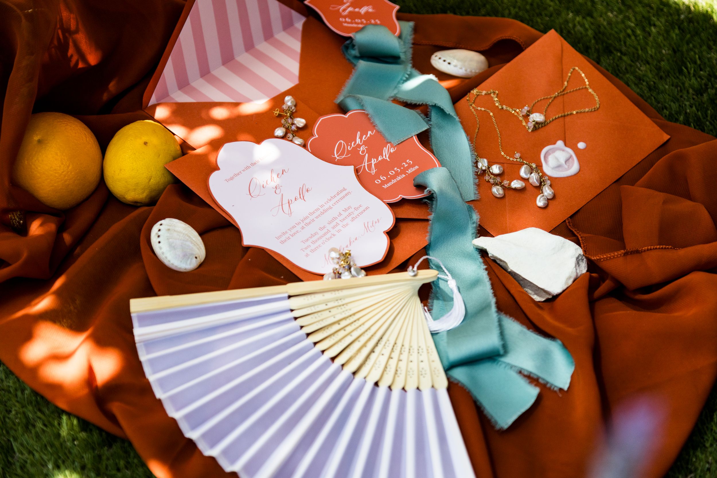 Decorative paper fans and ribbons in teal and white colors arranged on a rustic terracotta surface.