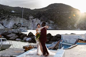 A couple dances together against a snowy mountain backdrop during sunset.