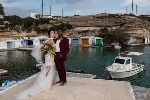 A scenic coastal wedding venue in Malta with boats docked in a turquoise Mediterranean harbor.
