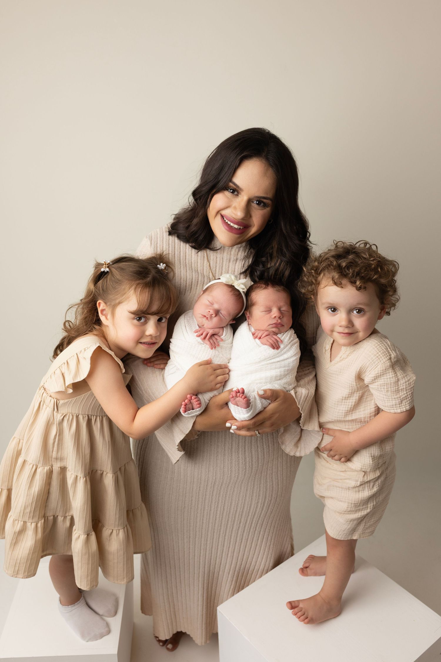 Family portrait with children in coordinated neutral-toned outfits.