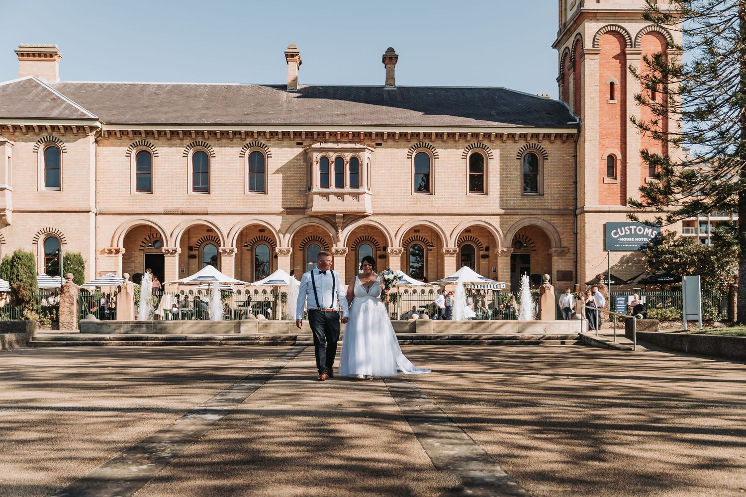 Wedding photography at a grand Spanish colonial style building with arched walkways.