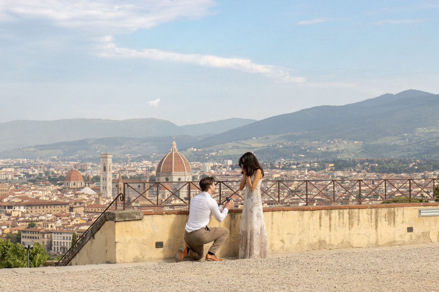 Scenic rooftop view overlooking Florence, Italy with the iconic Duomo cathedral and mountains in the background.